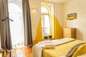 een slaapkamer met een bed en een bus aan de muur bij INT Lisbon Suites in Lissabon