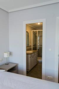オンダリビアにあるTxingudi by Basquelidaysのベッドルーム(白いベッド1台付)、バスルーム