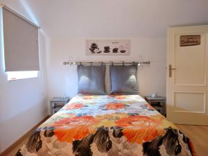 a bedroom with a bed with a colorful blanket at Casa Aurora in Penacova