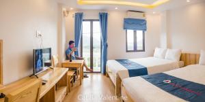 a man is sitting in a hotel room at CAT BA VALENTINE Central Hotel in Cat Ba