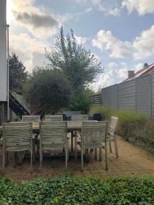 een houten tafel en vier stoelen rond een tafel bij Villa Georges met tuin en sauna in Koksijde