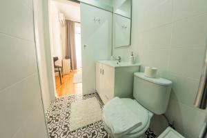een witte badkamer met een toilet en een wastafel bij INT Lisbon Suites in Lissabon