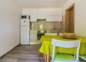 een keuken met een tafel en een witte koelkast bij Apartments Nicole in Pula