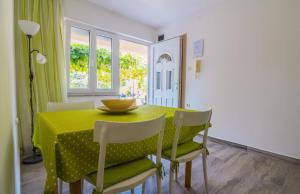 a dining room with a yellow table and chairs at Apartments Nicole in Pula