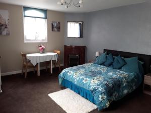 1 dormitorio con cama, mesa y ventanas en Maison Vuyk, en Nalliers
