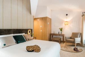 a bedroom with a large white bed and a chair at Boutique Hotel Sant Roc & Spa in Mahón