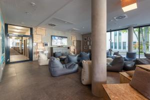 eine Lobby mit Sofas und einem TV in einem Gebäude in der Unterkunft the niu Timber in Esslingen
