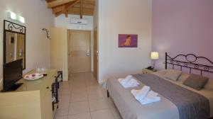 a bedroom with a bed and a desk and a television at 4epoches in Steni Vala Alonissos