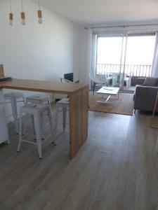 - un salon avec une table, des chaises et un canapé dans l'établissement Plage des Minimes PONANT 6 VUE MER, à La Rochelle