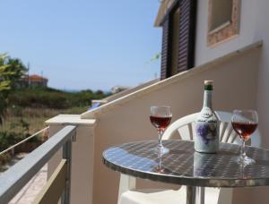 a table with two glasses and a bottle of wine at Villa Dream Garden in Agios Georgios