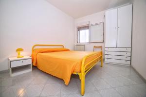 トッレ・パリにあるAppartamento Nettunoのベッドルーム1室(オレンジ色のベッドカバー付)