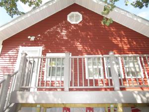 een rood bakstenen huis met een witte veranda bij The Bear Den in Ironwood