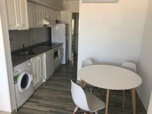 cocina con mesa blanca, mesa y sillas en Ático Port La Ràpita, en Sant Carles de la Ràpita