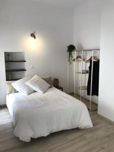 Un dormitorio blanco con una cama blanca y un armario. en Cal Morrudet, en L'Ametlla de Mar
