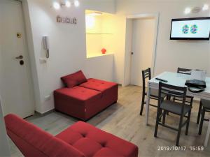 a living room with a red couch and a table at Casa Vacanze Dany in Taranto +19 photos