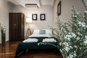 a bedroom with a bed with green sheets and flowers at Apartamenty na Starówce / Old Town apartments in Toruń