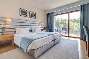 a hotel room with a bed and a balcony at Hotel Rural Vale Do Rio in Oliveira de Azemeis +68 photos