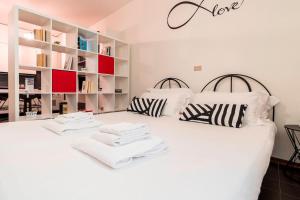a bedroom with two white beds and bookshelves at Italianway - Polese 36 B in Bologna