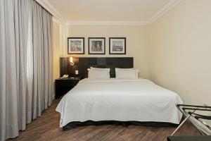 Cama ou camas em um quarto em Rockefeller by Slaviero Hotéis
