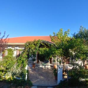 un jardín con un arco y árboles frente a un edificio en Villa Dream Garden, en Agios Georgios