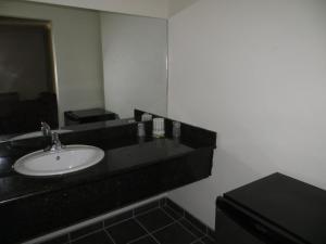 a bathroom with a sink and a mirror at The Oaks Motel in Oakland