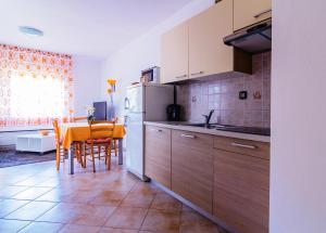 a kitchen with a table and a white refrigerator at Apartments Nicole in Pula