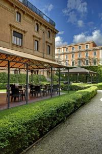 a patio with tables and chairs in front of a building at Villa Spalletti Trivelli - Small Luxury Hotels of the World in Rome