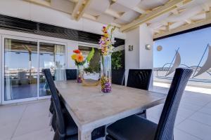 a dining room table with chairs and vases of flowers at Vila Marina - Luxurious apartment - Sea view in Vilamoura