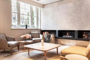 a living room with a fireplace and chairs and a table at The Prince Akatoki London in London