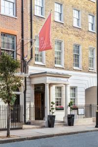 a red flag flying in front of a building at The Prince Akatoki London in London