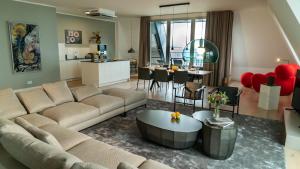 ein Wohnzimmer mit einer Couch und einem Tisch in der Unterkunft FIRST im FIRST Sellin, Penthouse Meer & Meer mit phänomenalem Ostseeblick in Ostseebad Sellin + 18 Fotos