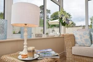 a table with a lamp and a cup of coffee at The Old Dairy B&B in Exmouth