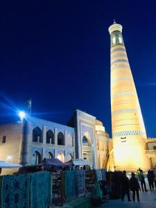 a large building with a lighthouse in front of it at Khiva Angarik Darvoza in Khiva