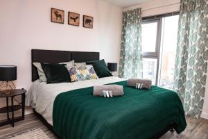 a bedroom with a bed with a green blanket at Paramount Views in Swindon +43 photos