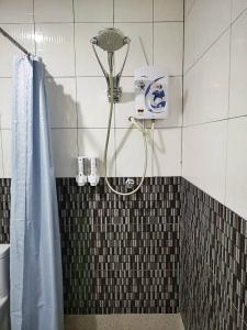 雙溪大年的住宿－梅利爾頓酒店，浴室设有蓝色淋浴帘和淋浴