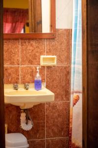 een badkamer met een wastafel, een toilet en een spiegel bij Planet Hostel in San Cristóbal de Las Casas