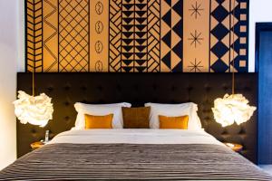 阿比让Boutique Hotel Particulier的卧室里有一张大床，上面有黄色枕头