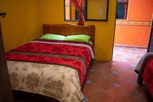 een slaapkamer met een bed in een gele kamer bij Planet Hostel in San Cristóbal de Las Casas