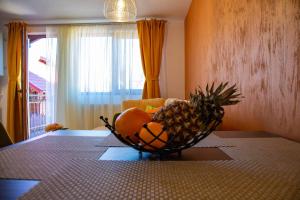 - un bol de fruits sur une table avec un bol d'ananas dans l'établissement Apartamente Primaverii 2, à Buşteni