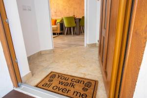 a door with a sign that says you can walk all over me at Apartamente Primaverii 2 in Buşteni