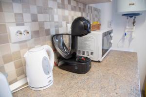 a kitchen counter with a coffee maker and a microwave at Apartamente Primaverii 2 in Buşteni