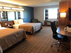 Habitación de hotel con 2 camas y escritorio en Quality Inn & Suites Watertown Fort Drum en Calcium