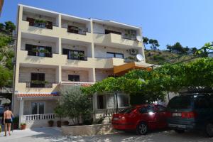 a building with two cars parked in front of it at Apartments Karlo in Omiš