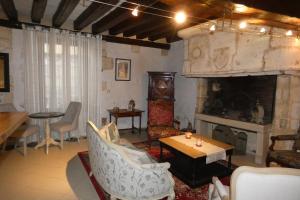 LE LOGIS ST PERE في سانسير: غرفة معيشة بها موقد وطاولة وكراسي