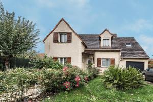 a house with some flowers in the yard at Chambres d'hôtes près de Disney in Fontenay-Trésigny