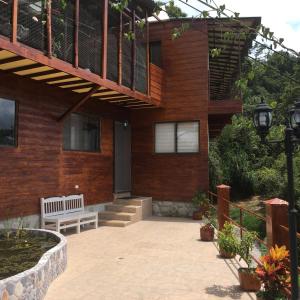 a house with a bench in front of it at Mirador Finca Morrogacho in Manizales