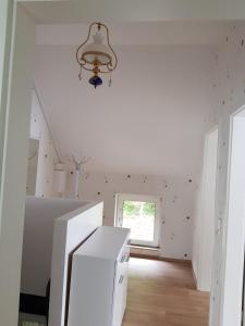 a white kitchen with a window and a chandelier at Gartenblick in Oldenburg