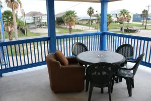 a balcony with a table and a chair and a table and chairs at American Inn Port O'Connor in Port O'Connor