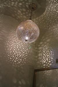 a ceiling with a glass chandelier in a bathroom at Riad Zamzam in Marrakesh