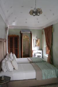 a bedroom with a large bed with white pillows at Riad Zamzam in Marrakesh